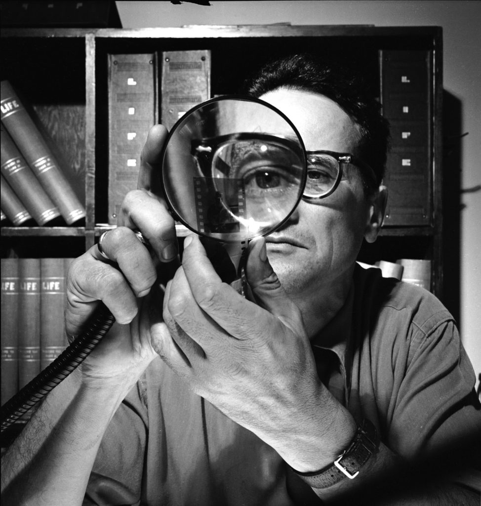 Andreas Feininger looking at negatives with a magnifying glass. (Photo by Andreas Feininger/The LIFE Picture Collection / Shutterstock)