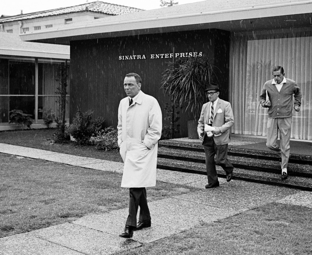 Frank Sinatra and associate leave his offices on the grounds of Warner Bros. Studios, 1965.