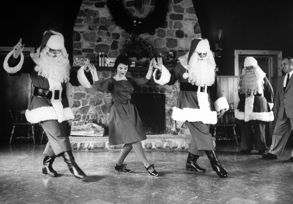 Ken Berends and Bill Burslem practice a soft-shoe with faculty member Joy Merkel in Santa Claus training class at Santa Claus School, 1961.
