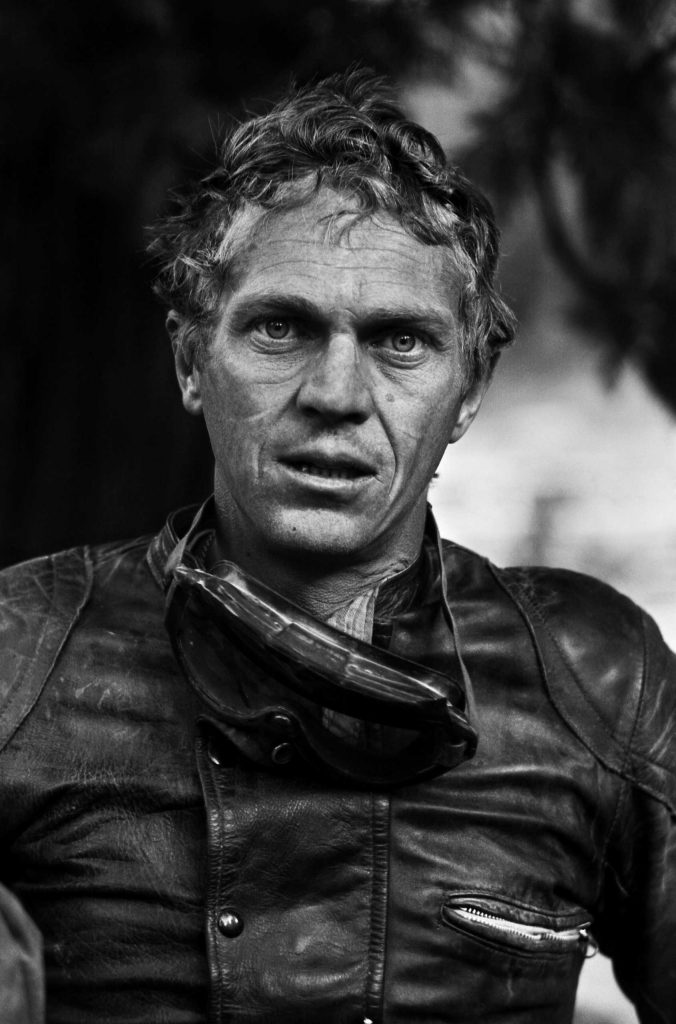 Steve McQueen takes a break during a motorcycle race across the Mojave Desert, 1963.